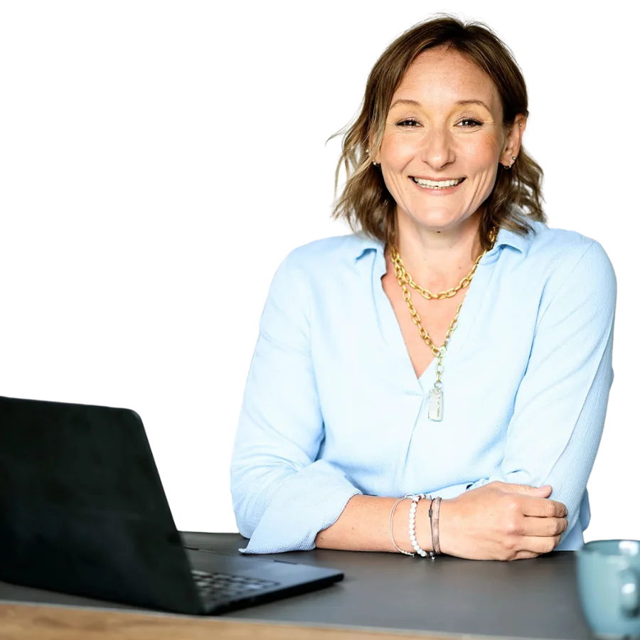 Elena Scherschneva, psychosoziale Beraterin und Trainerin, am Schreibtisch mit aufgeklapptem Laptop